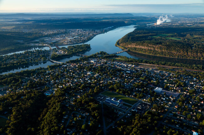 An aerial view of a large city on the banks of the branching Susquehanna River.