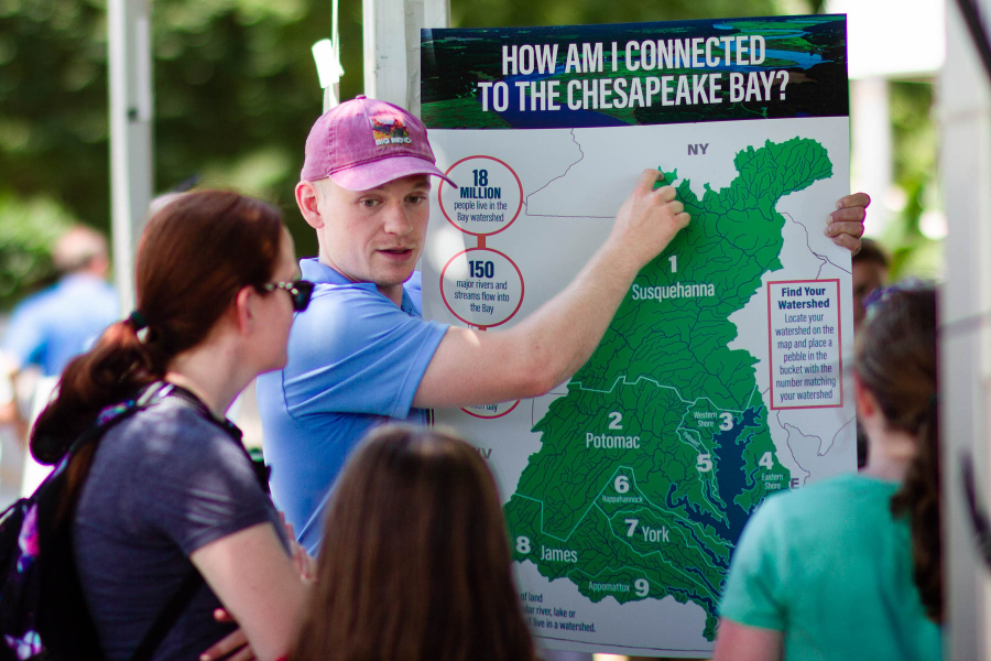 Staff points out New York on a map of the watershed for festival attendees.