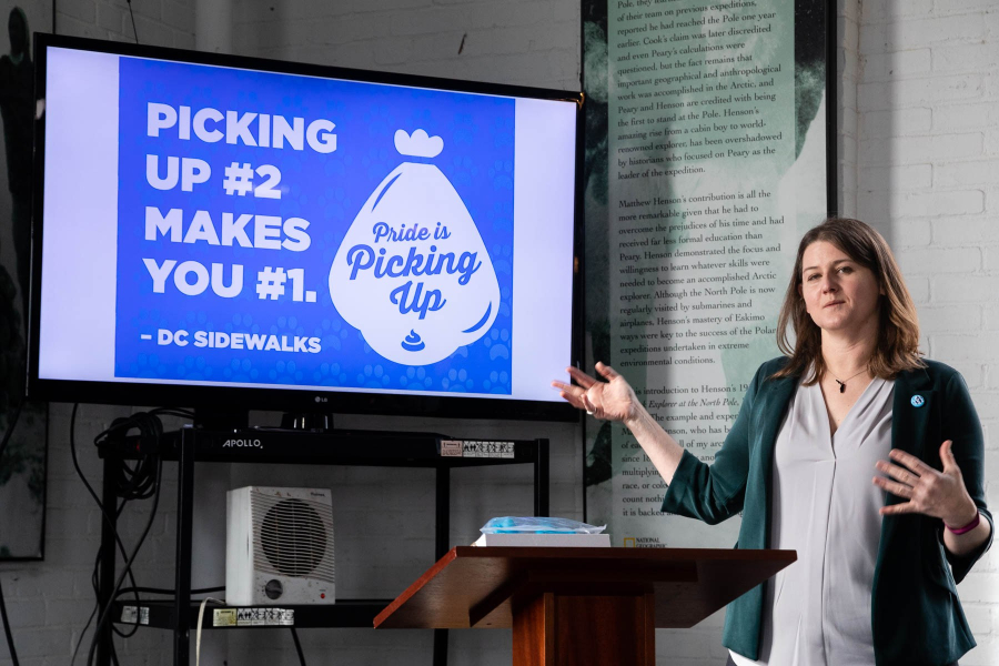 Julie stands in front of a screen giving a presentation.