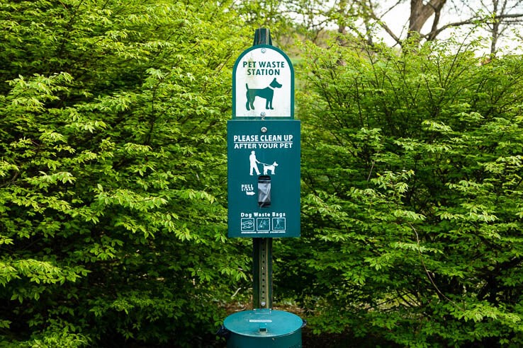 Pet waste station sign with plastic bags